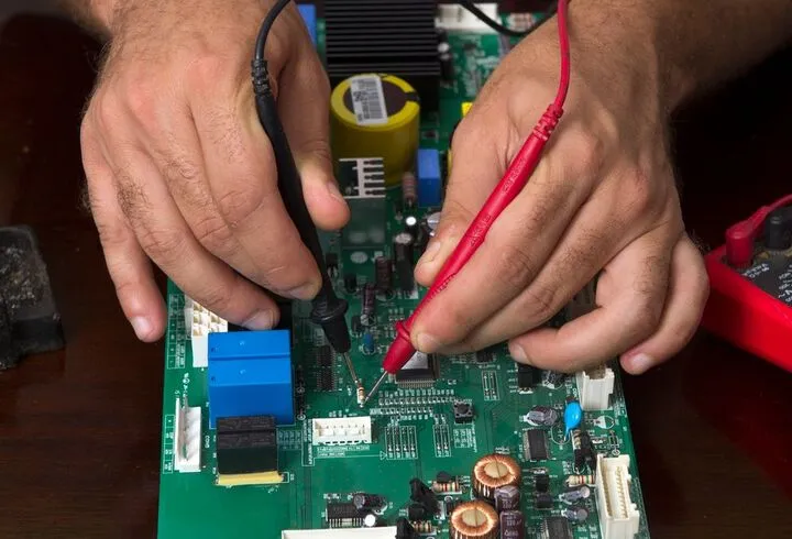 Technician performing AS/NZS 3760 portable appliance testing using a PAT tester on electrical equipment in a Sydney business